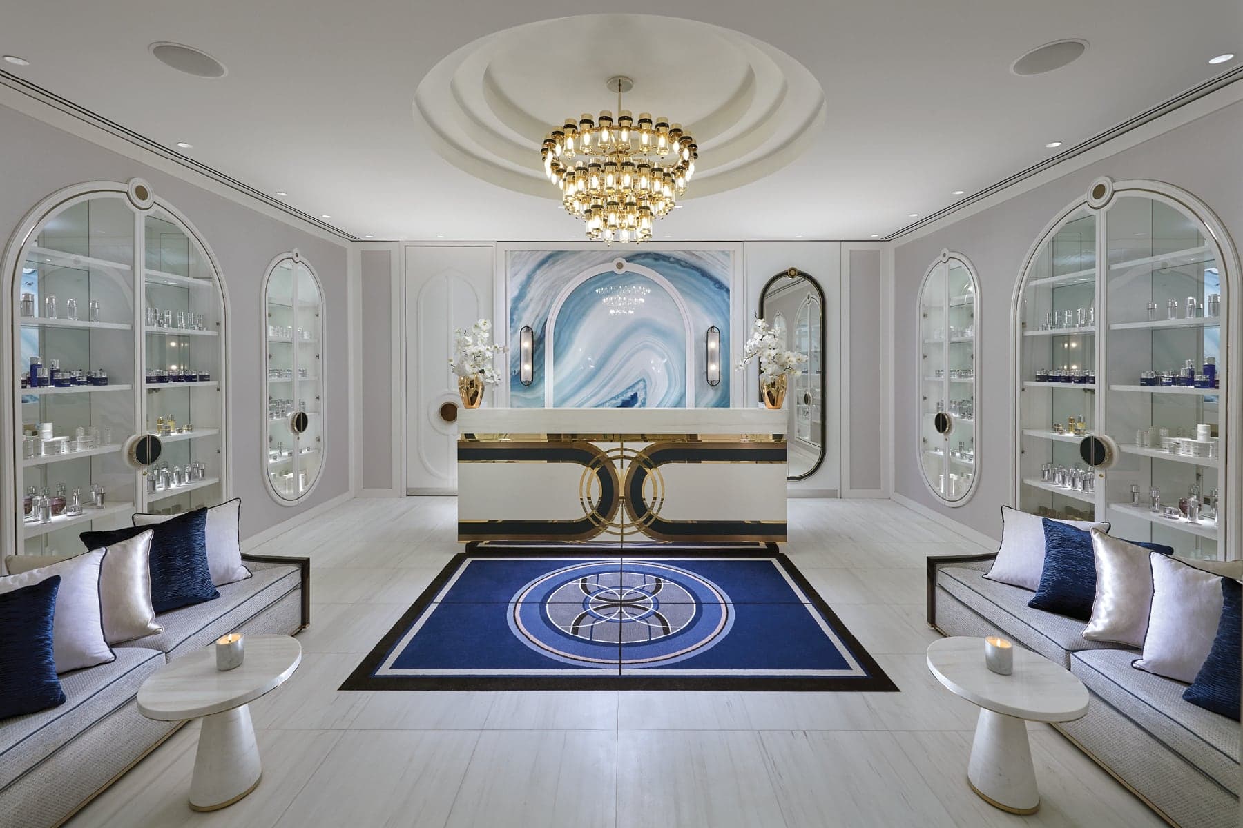 Crown Spa Perth reception lobby with gold chandelier, blue marble feature wall, product vitrines and navy velvet seating
