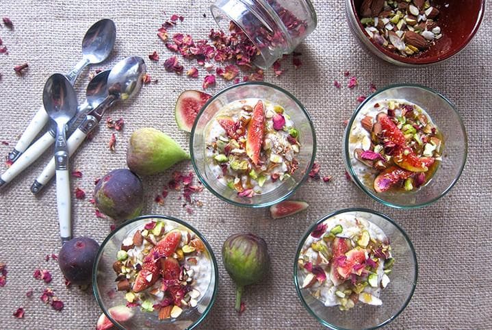 Creamy chia seed pudding topped with toasted pistachios, almonds and fresh fig slices in a glass bowl