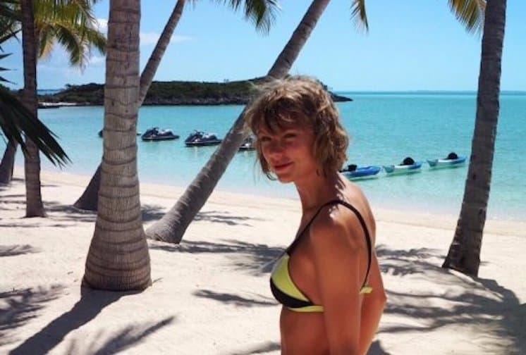 Woman with glowing, sunprotected skin enjoying the beach with ocean and sand in background