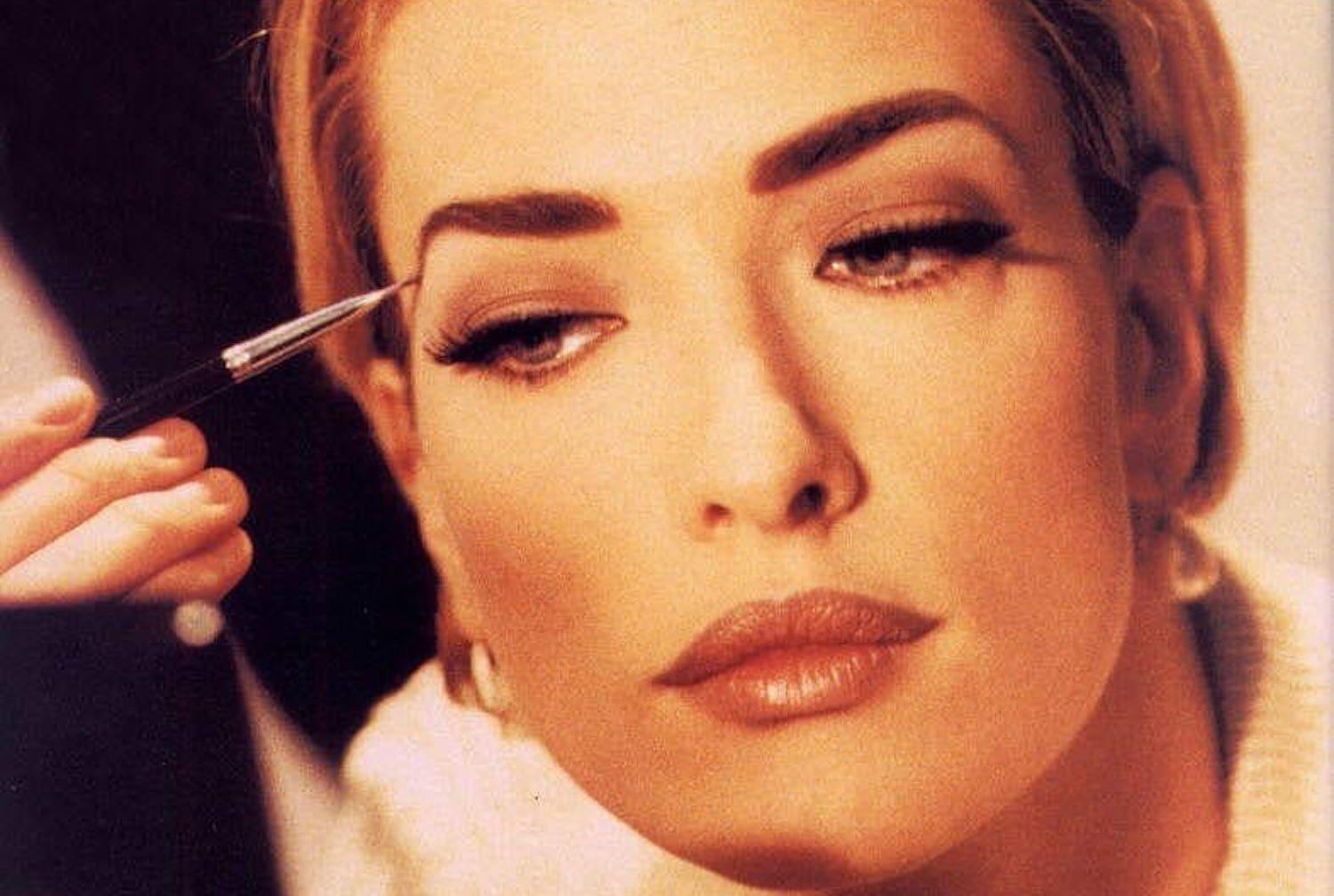 Beauty professional applying natural makeup with neutral tones and minimal contouring technique