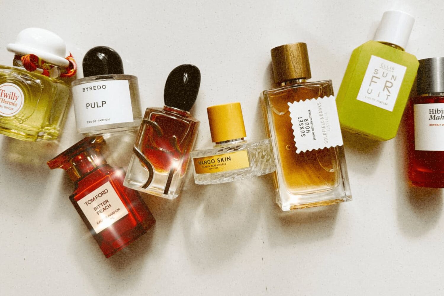 Luxury fragrance bottles arranged on a neutral surface, showcasing premium perfume collections