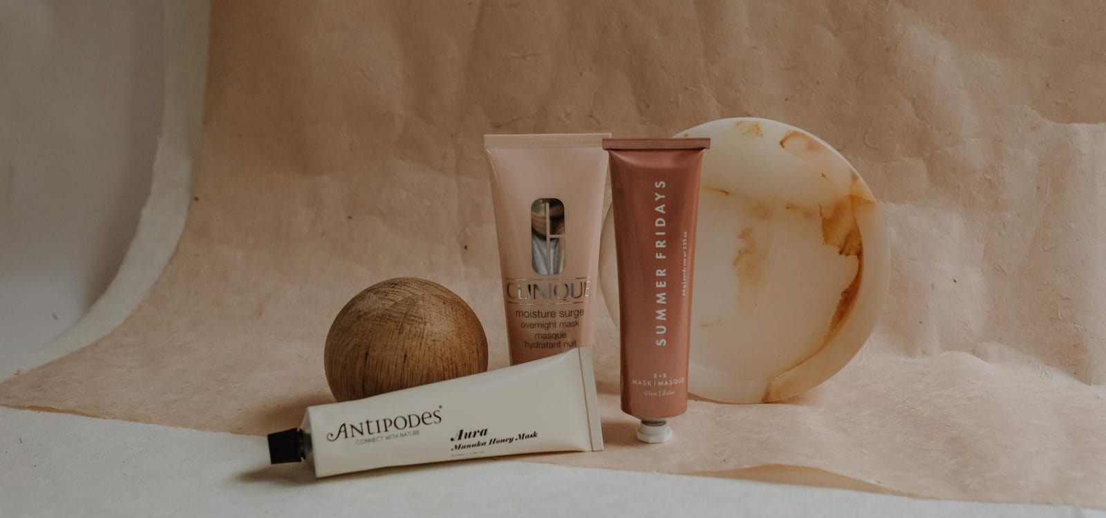 Luxury face mask products arranged on marble surface with botanical ingredients and skincare bottles