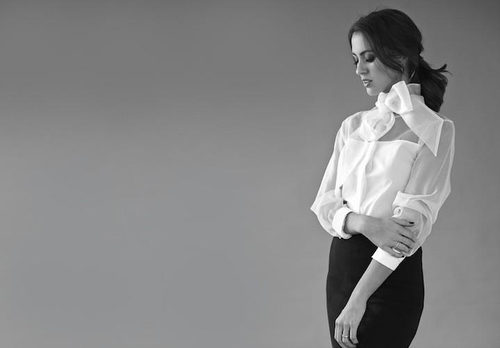 Woman wearing classic white shirt with minimal makeup and scraped-back hair