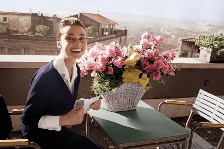 Audrey Hepburn with winged eyeliner, full brows and peachy pink lipstick in classic Hollywood glamour style
