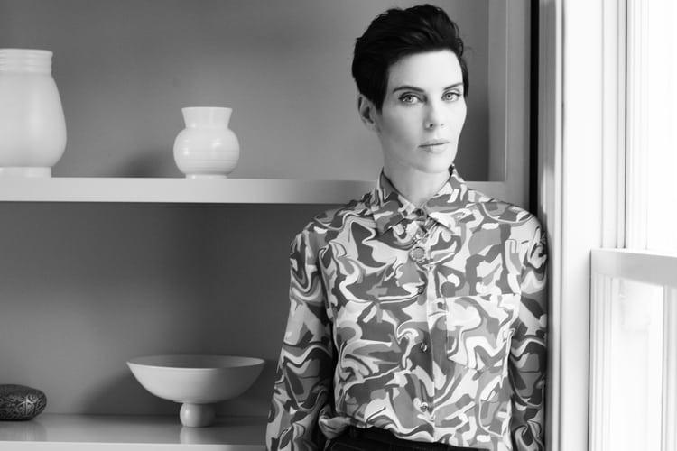 Karen Walker in her Auckland home, wearing minimalist makeup and dark hair, styled for an editorial portrait