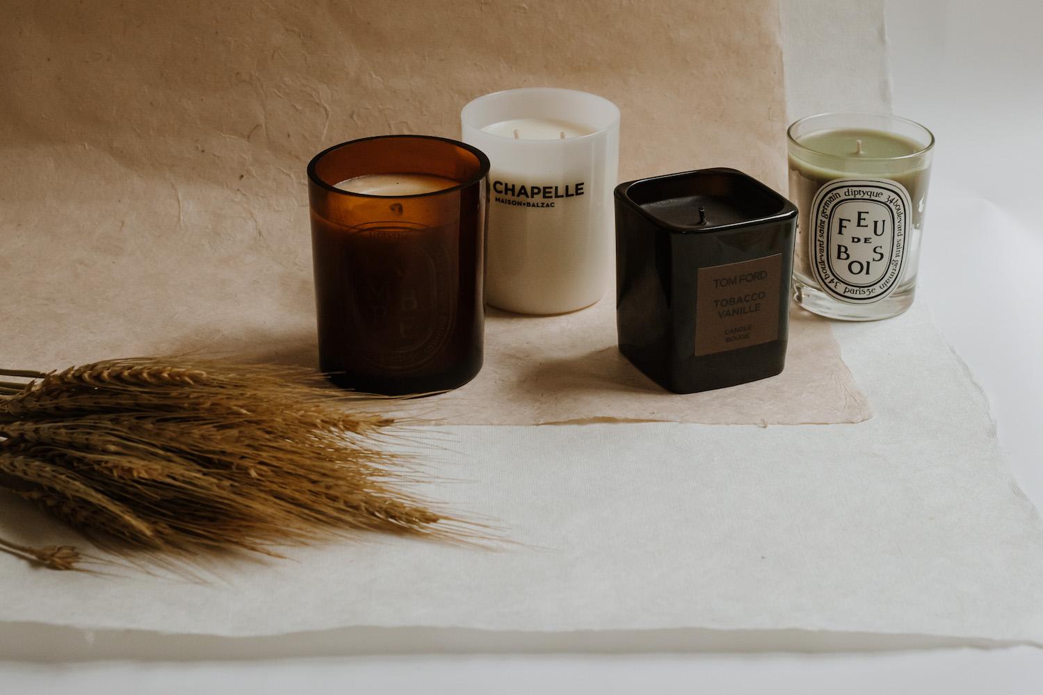 Collection of luxury scented candles arranged by season, displaying premium brands and glass vessels