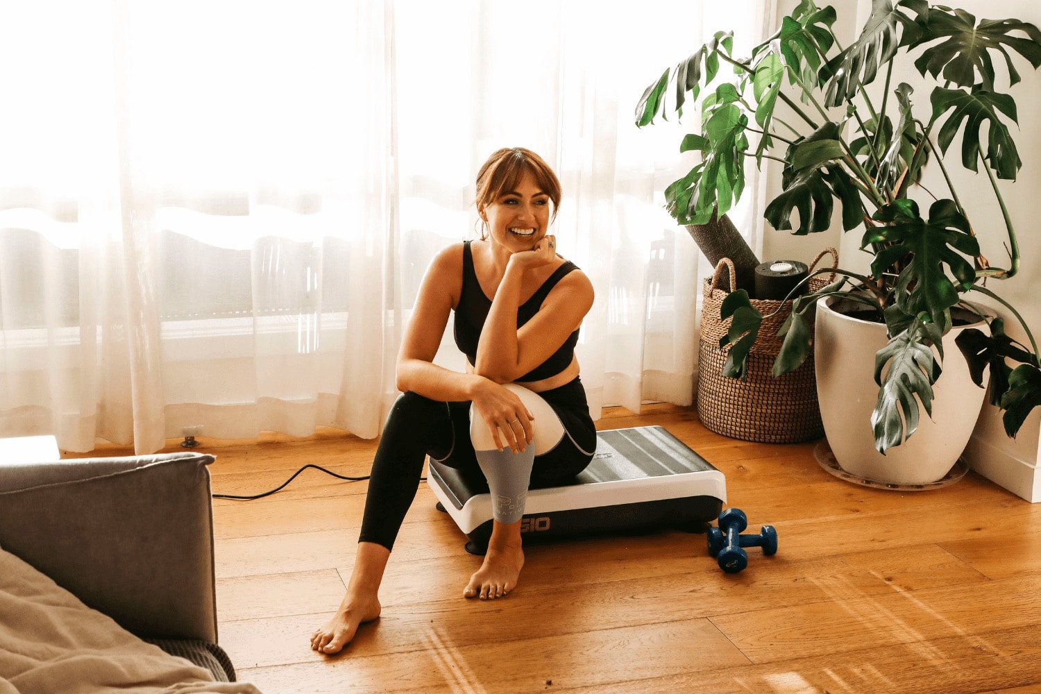 Woman performing a squat exercise on a Hypervibe G10 Mini vibration plate trainer