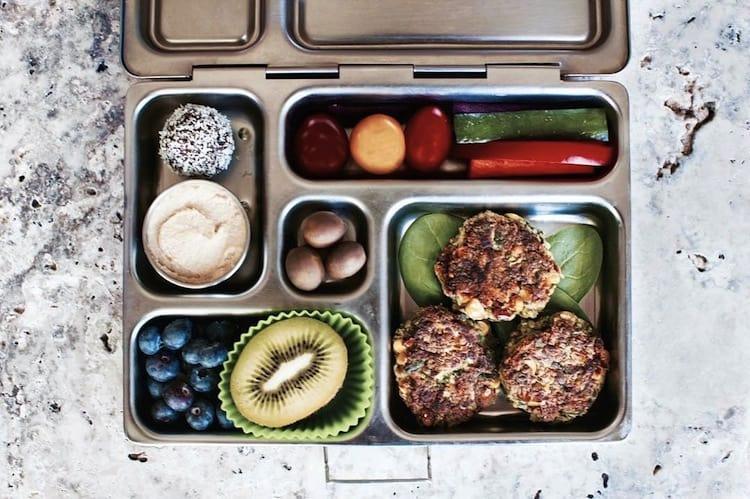 Overhead flat lay of fresh superfoods including avocado, blueberries, coconut water and protein powder on marble surface