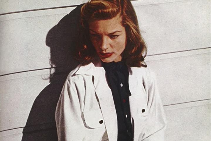 Lauren Bacall in classic 1940s Hollywood film still, showcasing signature bold brows, luminous skin and red lipstick