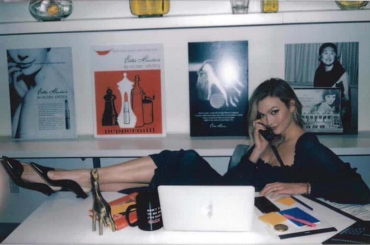 Karlie Kloss at her desk with organised beauty and wellness products