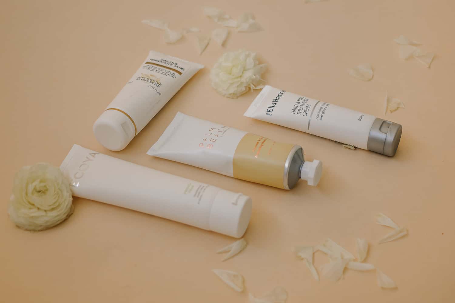 Four luxury hand cream products arranged on a neutral surface, showcasing premium Australian beauty brands