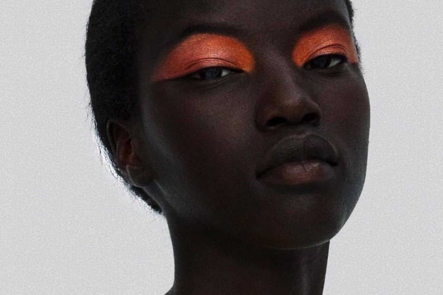 Array of eyeshadow palettes, liquid eyeshadow, and volumising mascara arranged on a neutral background