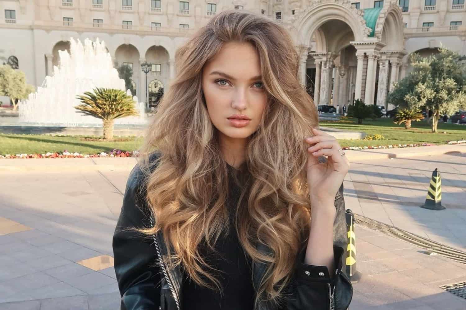 Woman with voluminous, salon-quality blowdry, hair lifted at the roots and glossy