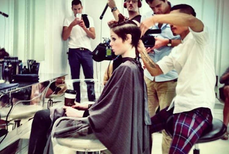 Woman with healthy, shiny hair being styled with a blow dryer and heat protectant product