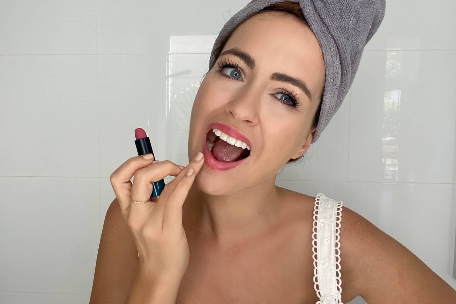 Woman wearing microfibre hair turban after shower, wrapping damp hair gently
