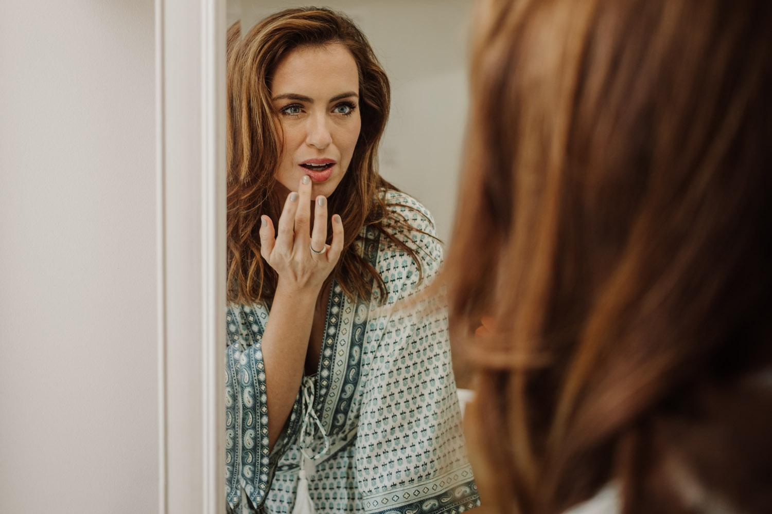 Model wearing warm orange lip colour and bronzed skin, styled for summer