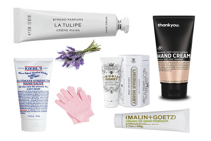 Selection of five luxury hand cream products displayed on a marble surface with fresh flowers