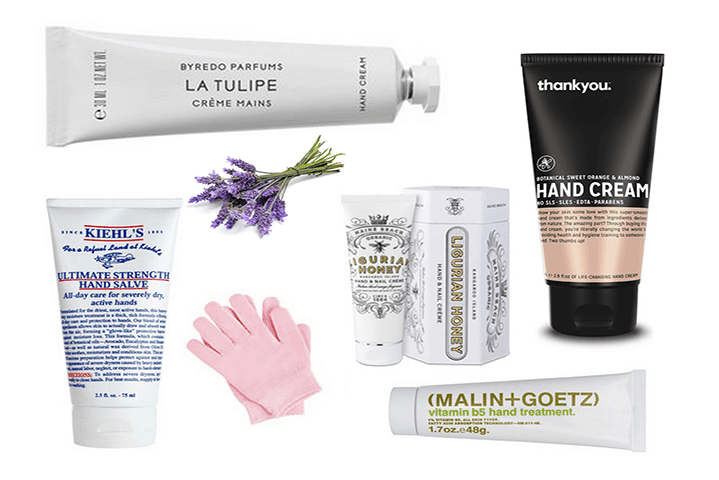 Selection of five luxury hand cream products displayed on a marble surface with fresh flowers