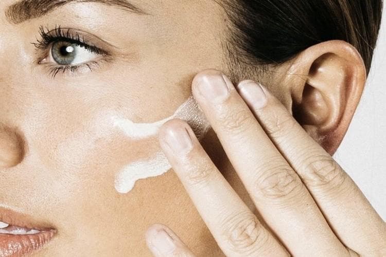 Skincare products including hydrating serum and moisturising cream displayed on marble surface with water droplets