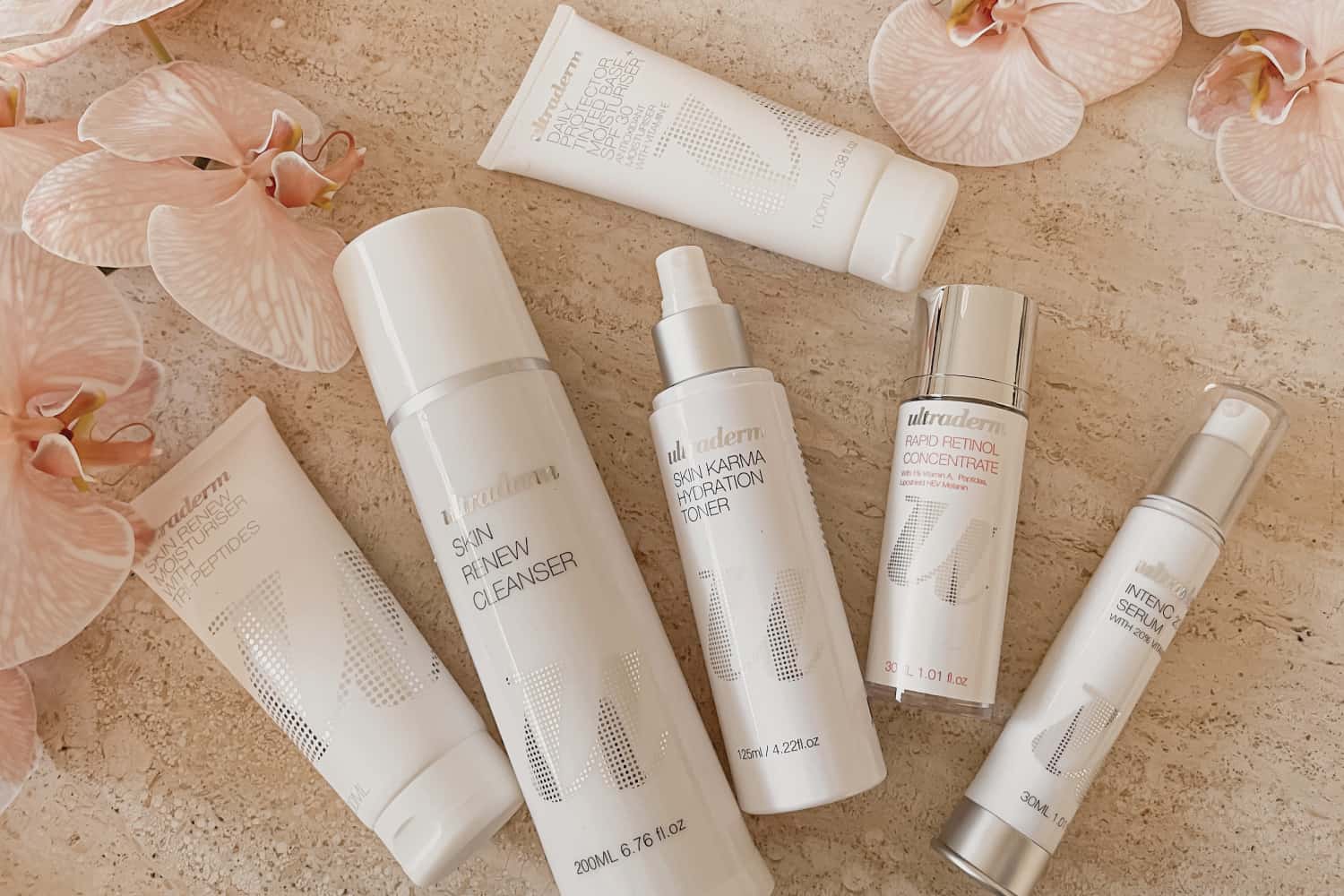 Pauline Valle, founder of Ultraderm, holding active skincare products including retinol and vitamin C serums