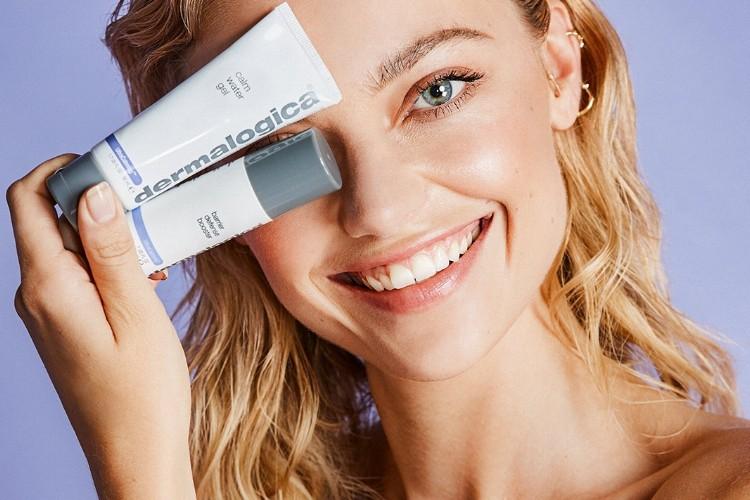 Woman with glowing, hydrated skin applying lightweight serum to face