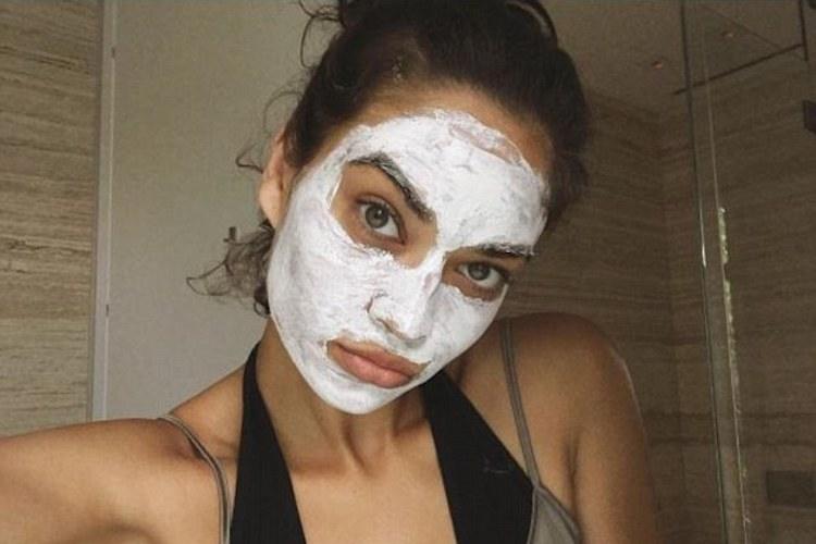 Luxury face mask products arranged on marble surface, including sheet masks and cream formulas