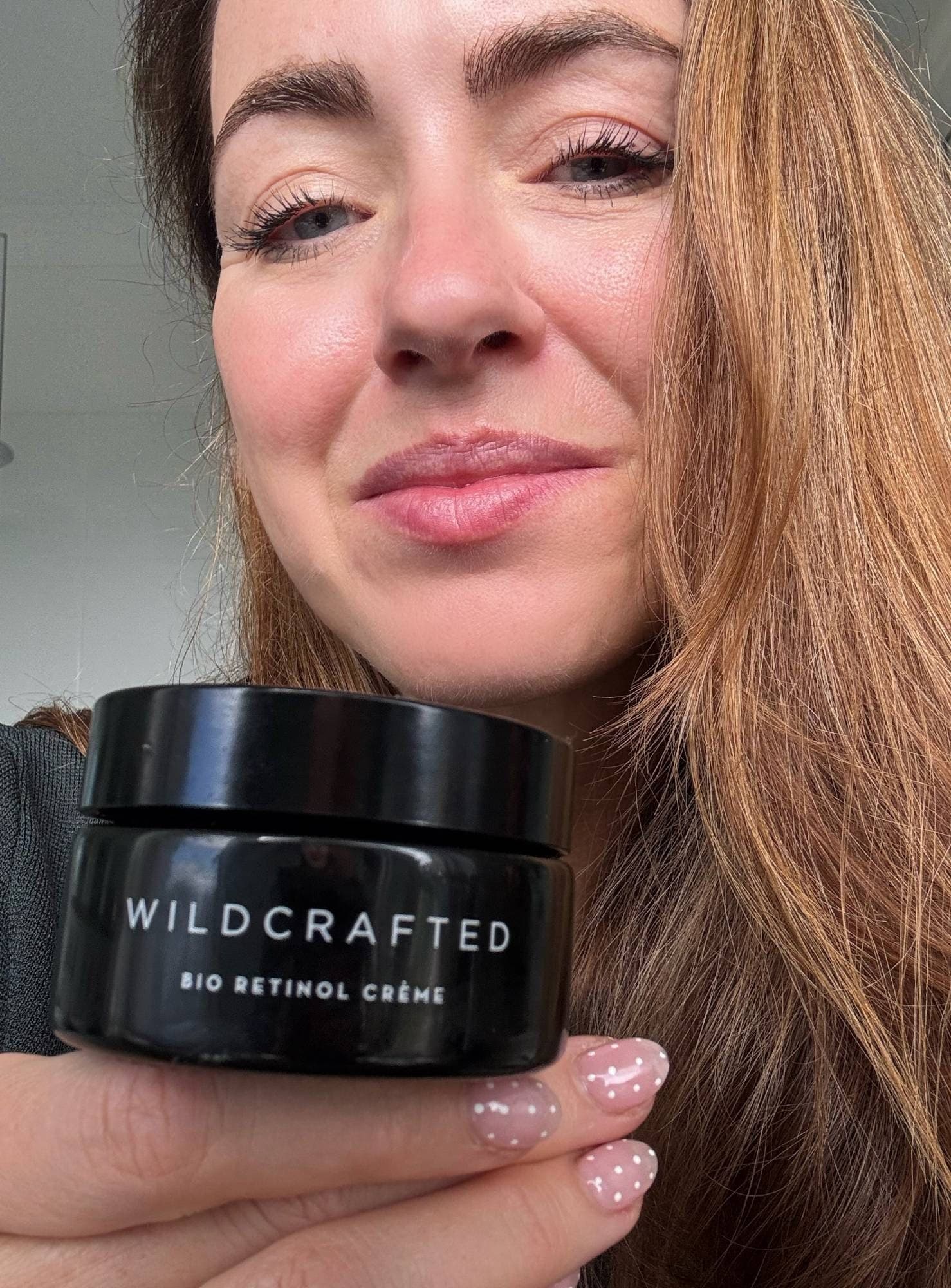 Close-up of Sigourney's face holding the Bio Retinol Crème jar