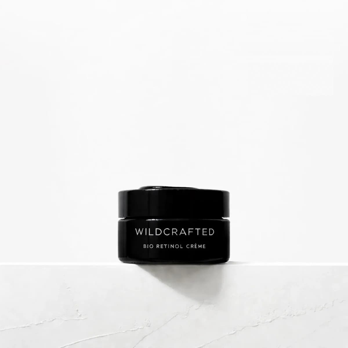 Wildcrafted Organics Bio Retinol Crème in its black 50g Miron glass jar on a white shelf