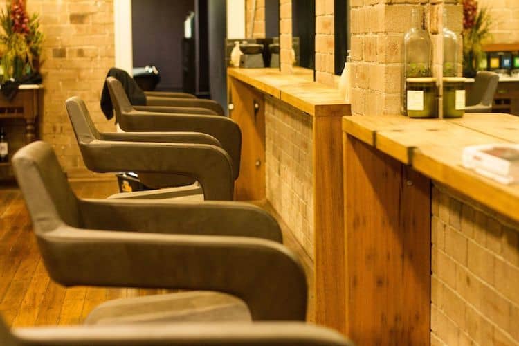 Luxury hair salon interior with lush gardens and wooden furnishings at Mr Burrows, Newtown