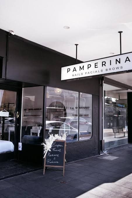 Black shopfront of Pamperina on Edgecliff Road, Woollahra, with a chalkboard and dried flowers by the door