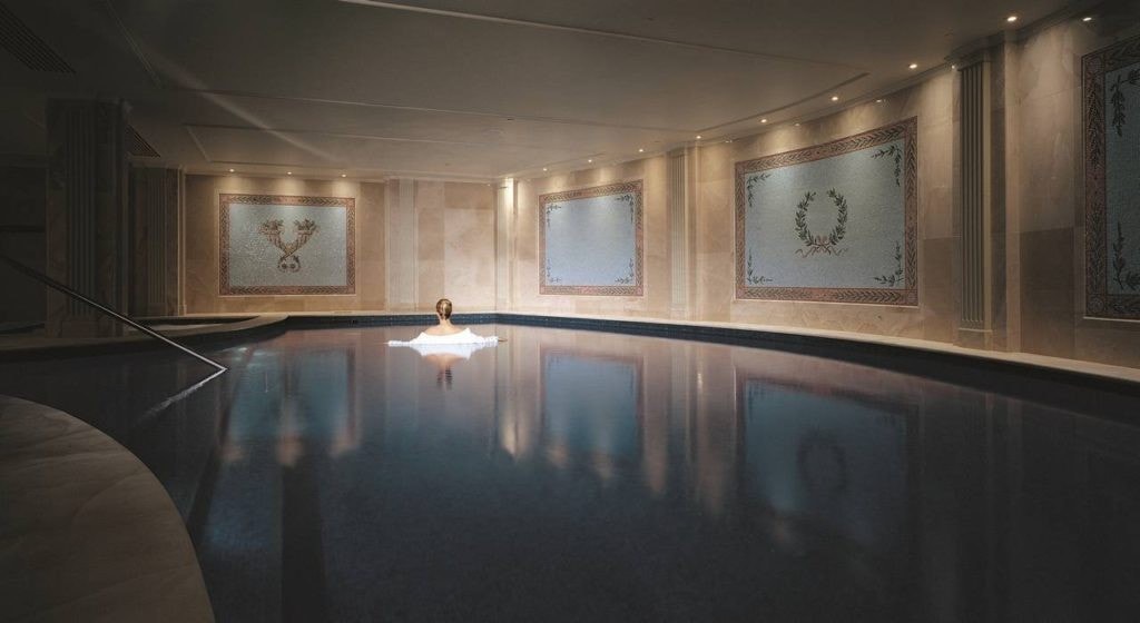 Lamplit indoor pool framed by mosaic wall panels at Aurora Spa, Palazzo Versace, Gold Coast
