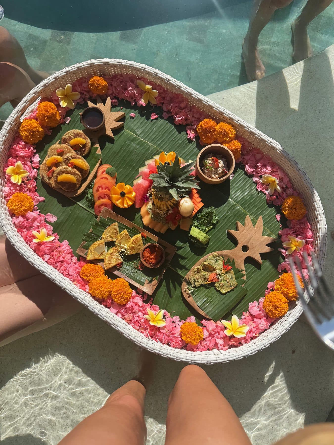 The floating breakfast at Escape Haven Bali, a rattan tray of fruit, marigolds and frangipani set adrift on the pool