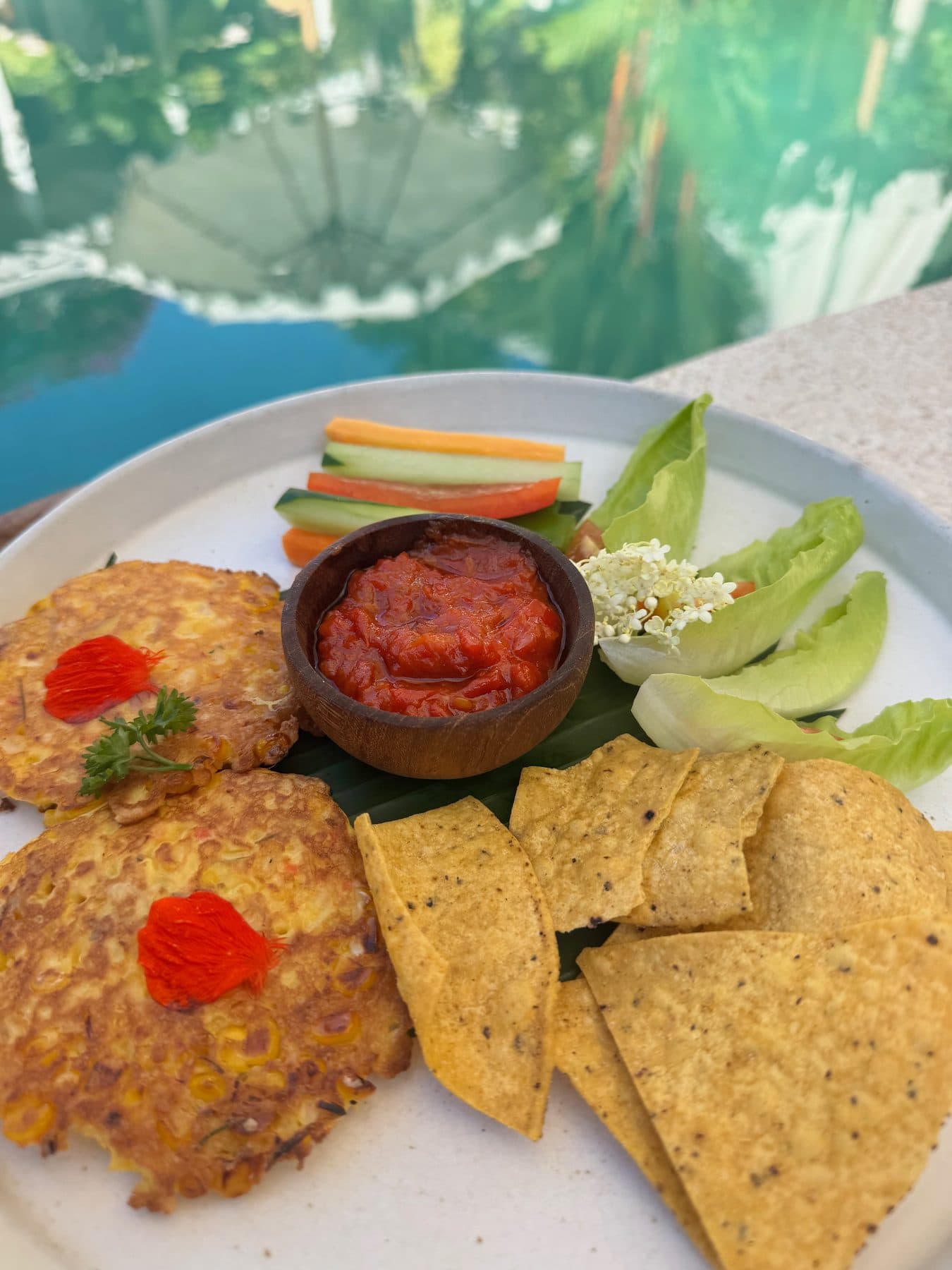 Corn fritters with sambal and crudites served beside the pool at Escape Haven, Canggu