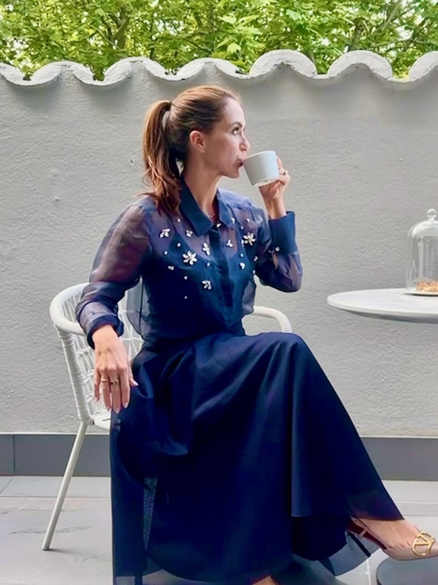 Sigourney sipping tea in profile on the terrace at The Royce Hotel Melbourne, tulle skirt and art deco surrounds