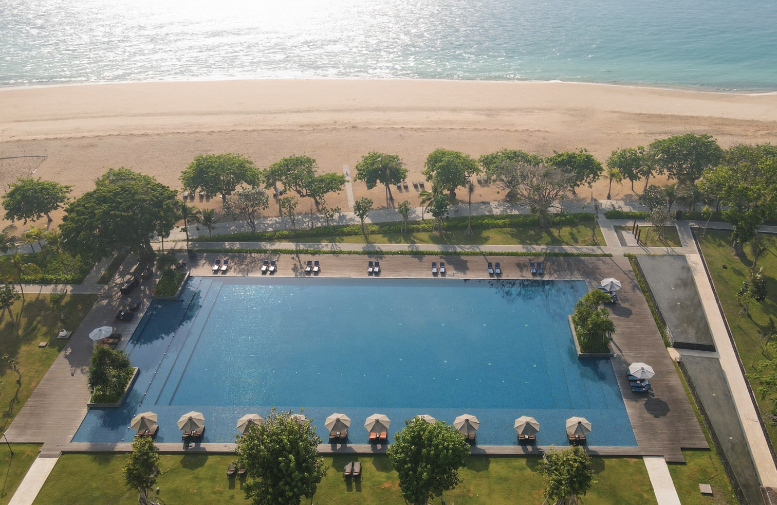 Aerial view of Sanur's coastline and lush tropical gardens surrounding Bali Beach Hotel and The Meru Sanur resort complex