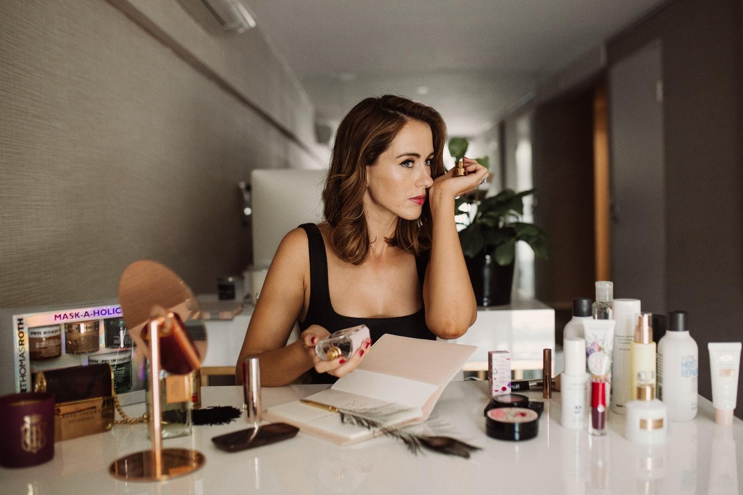 Sigourney Cantelo in a studio setting surrounded by beauty products and editing equipment