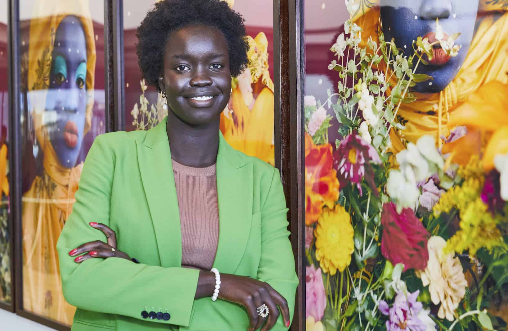 Visual artist Atong Atem wearing vibrant blue makeup and colourful accessories, showcasing creative beauty expression