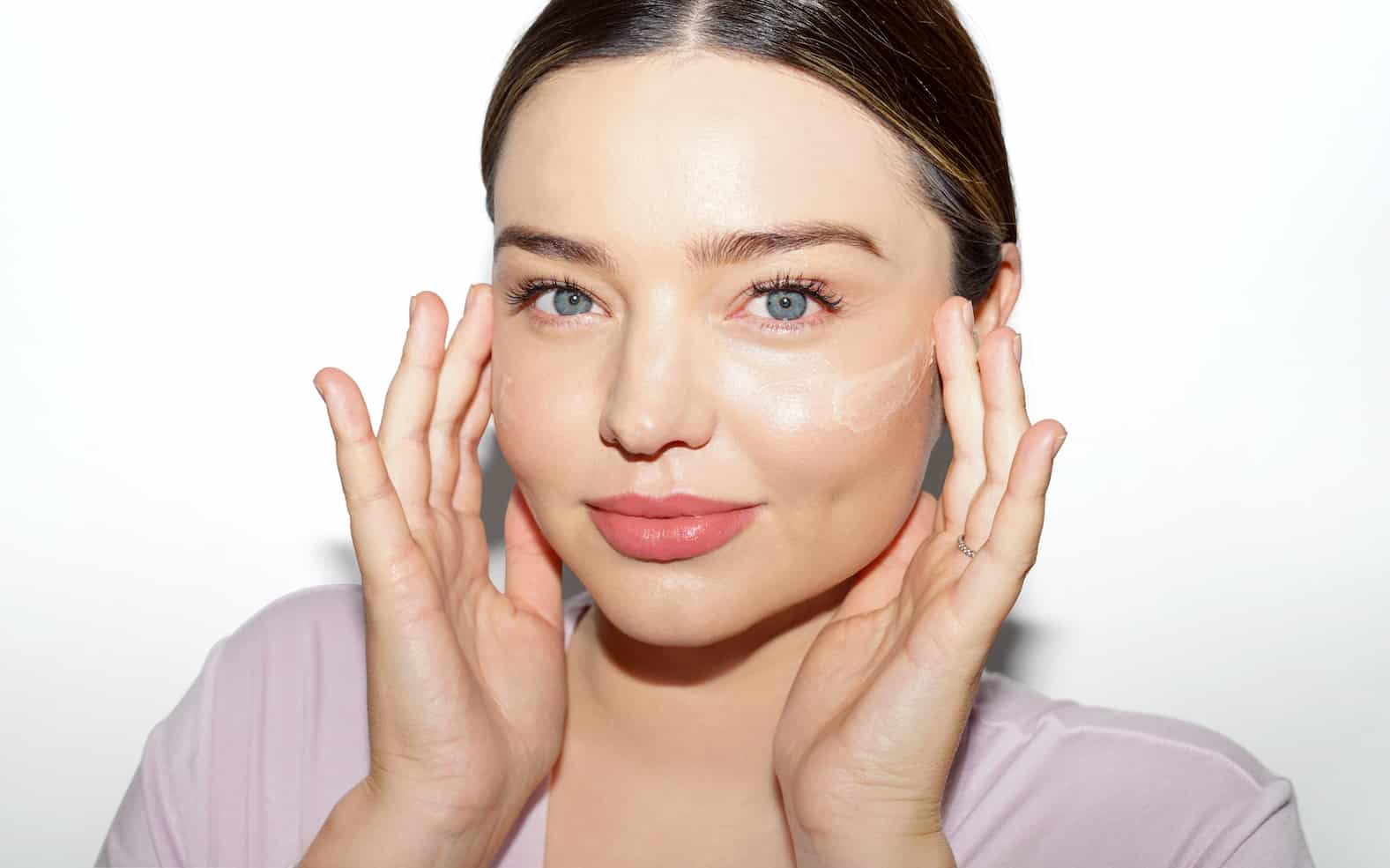 Miranda Kerr applying skincare product to her face during her morning beauty routine