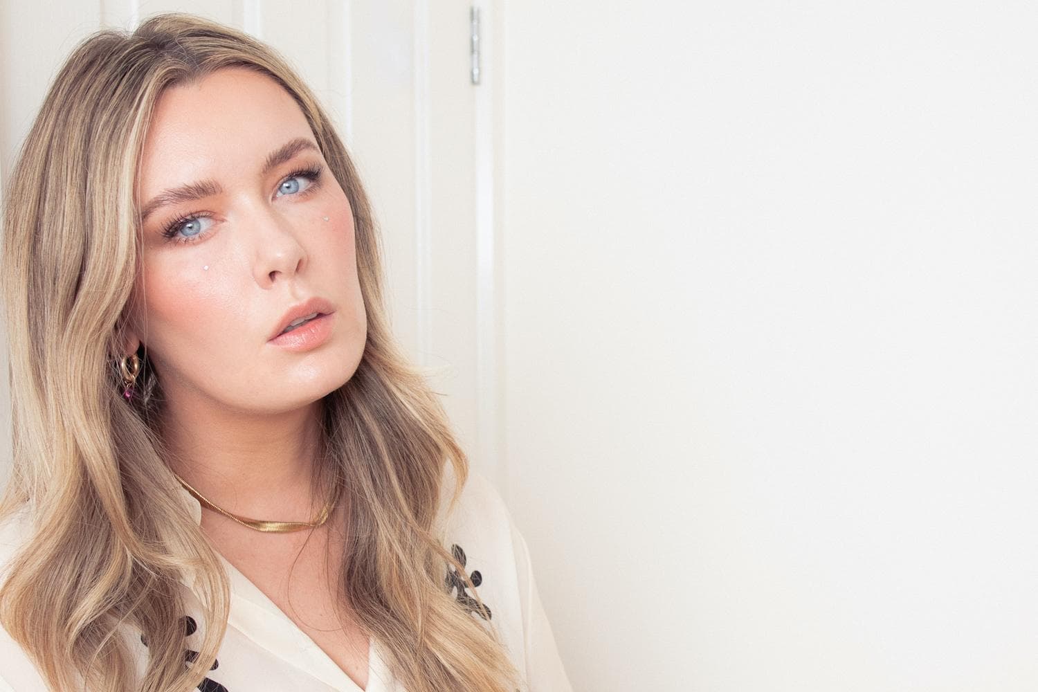 Portrait of Hannah English, a female scientist and beauty influencer, in a professional setting with skincare products visible