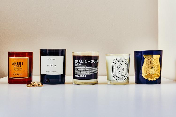 Luxury scented candles arranged on a minimalist shelf with neutral interiors and soft lighting