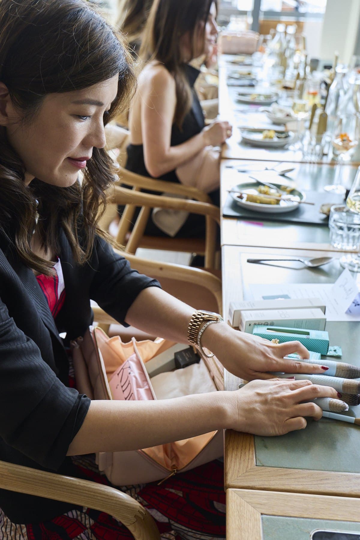 A guest at the long table going through her makeup bag