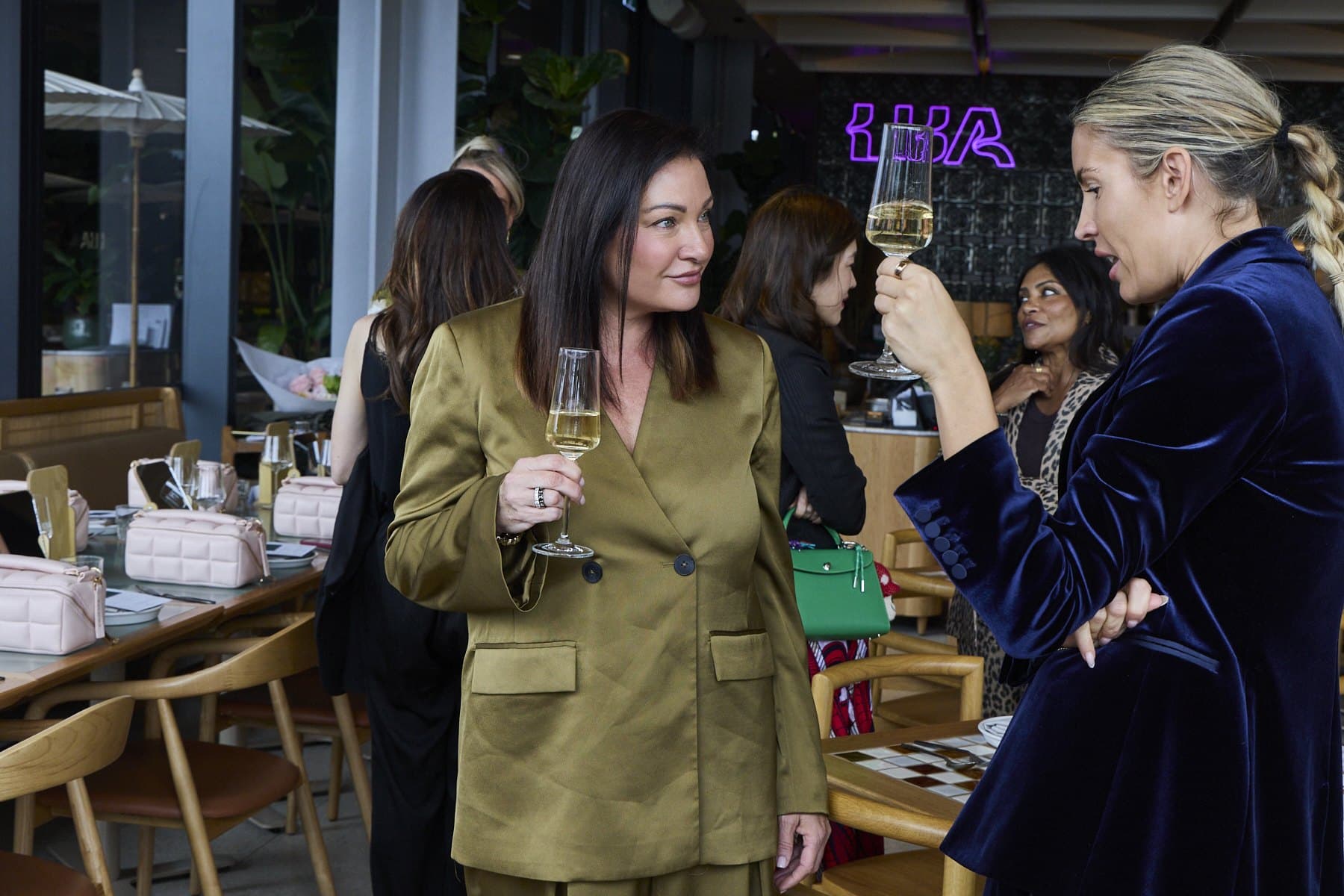 Two guests talking with glasses in hand at Lua