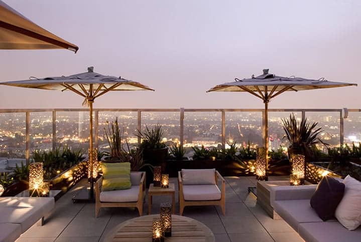 Glowing aquamarine plunge pool overlooking Los Angeles cityscape at night with city lights sparkling below