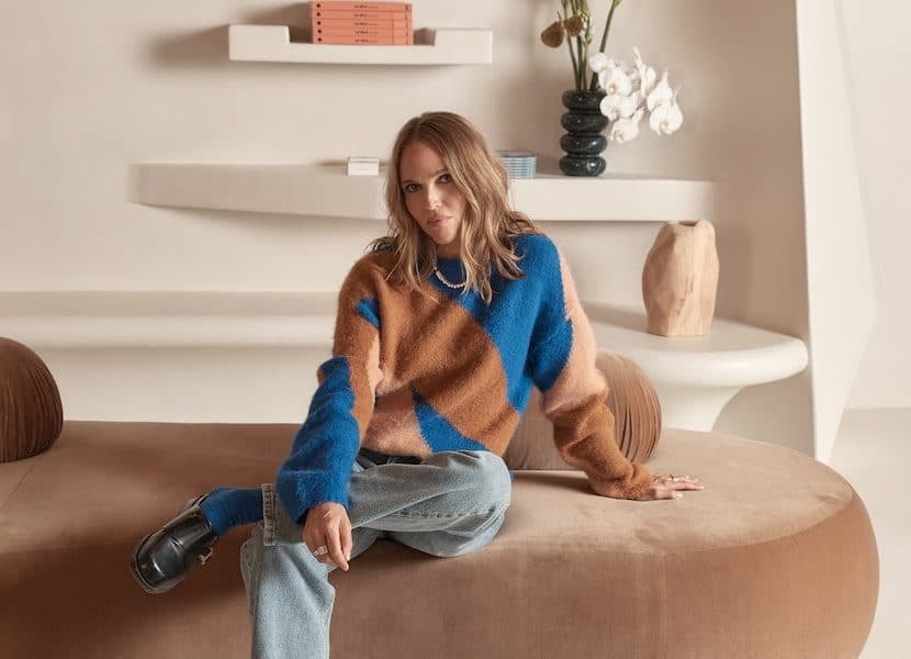 Nagnata founder Laura May Gibbs seated in colourblock knitwear inside the brand's sculptural Byron Bay flagship store, for Beautiful Inside by Beauticate