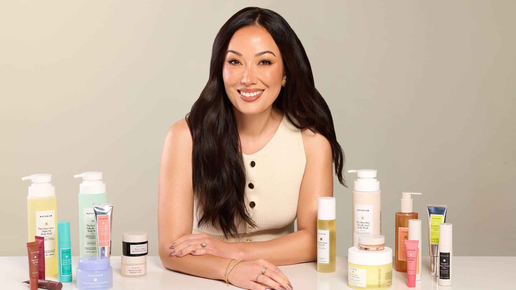 Susan Yara, founder of skincare brand Naturium, smiling beside her product line, for Beautiful Inside by Beauticate