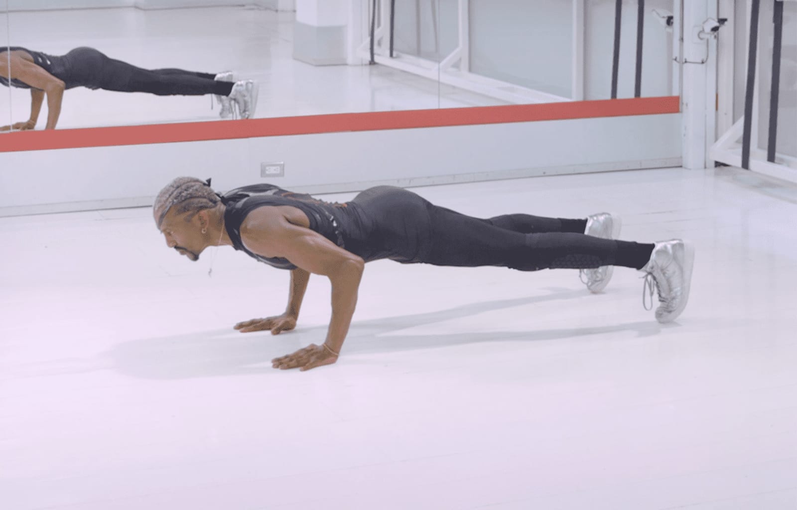 Professional female model performing high-intensity fitness training with personal trainer in studio setting