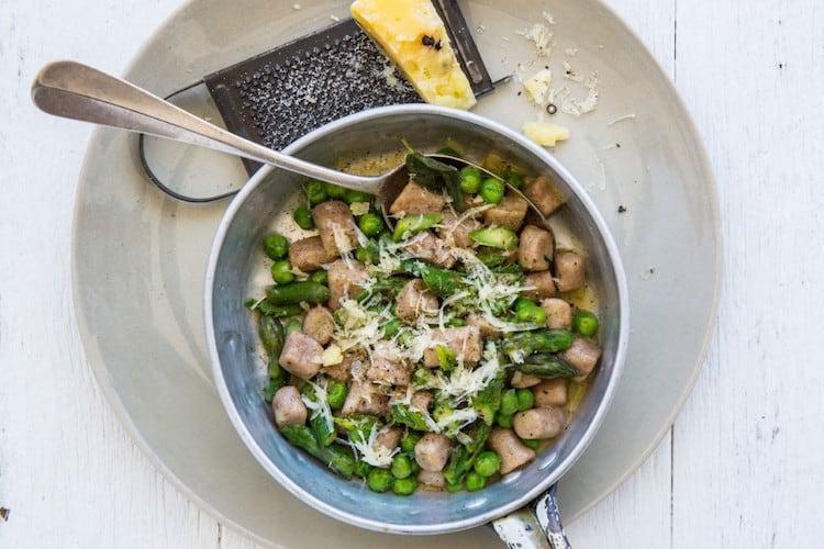 Colourful array of healthy pasta alternatives including zucchini noodles, cauliflower rice, teff gnocchi and shirataki noodles arranged on a neutral surface