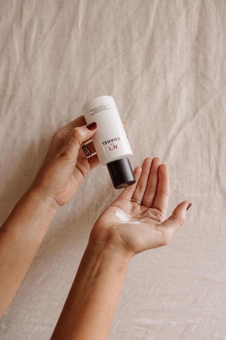 Hands tapping the No 1 de Chanel Powder-To-Foam Cleanser into an open palm