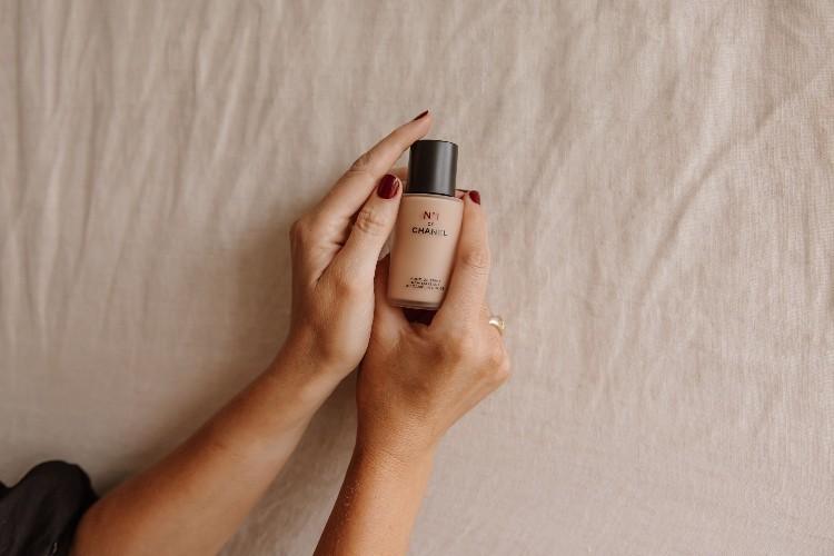 Hands cradling the No 1 de Chanel Revitalising Foundation bottle