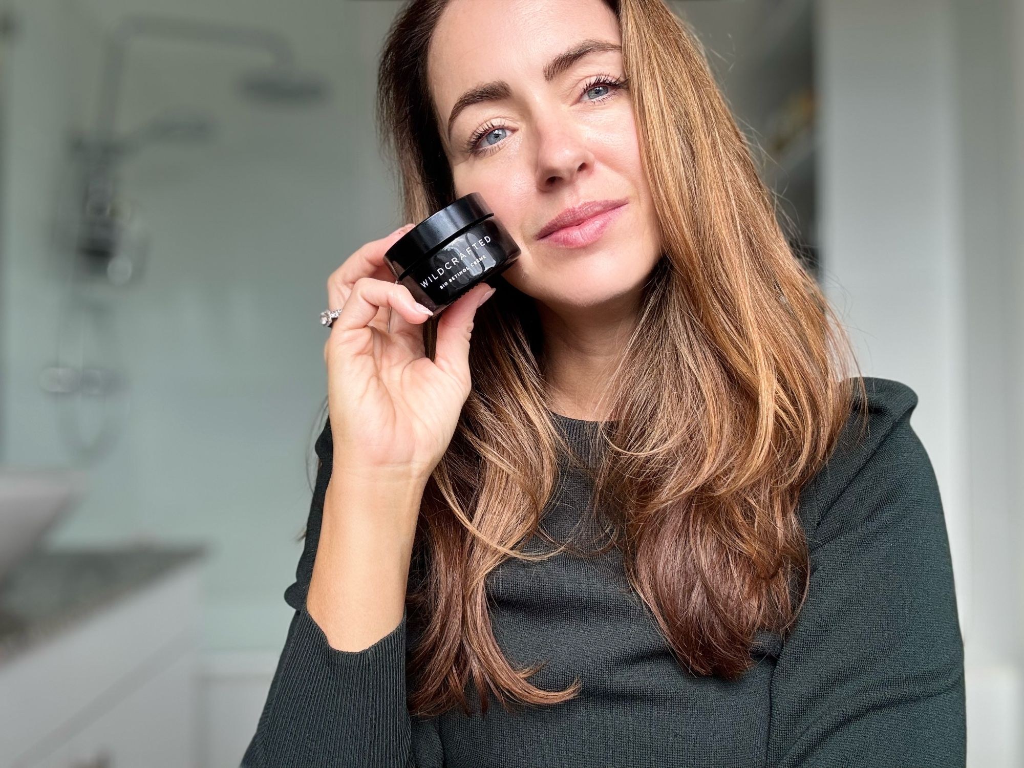 Sigourney holding the Bio Retinol Crème jar against her cheek